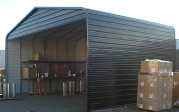 Extra tall carport, parking or outdoor metal storage area shown with shelving inside. Notice support bracing.
