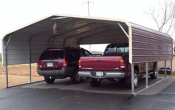 This picture shows a two car metal carport with round roof, brown siding and cream colored trim.