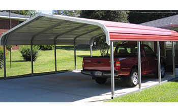 This is a common but popular red rounded roof style carport with white trim on gravel.