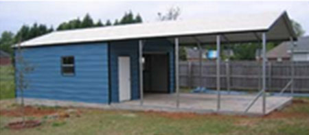 A metal utility storage garage with roll up door and attached carport cover for parking.