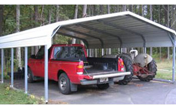 Notice the standard metal carport with rounded roof shoing a truck and tractor parked neatly.